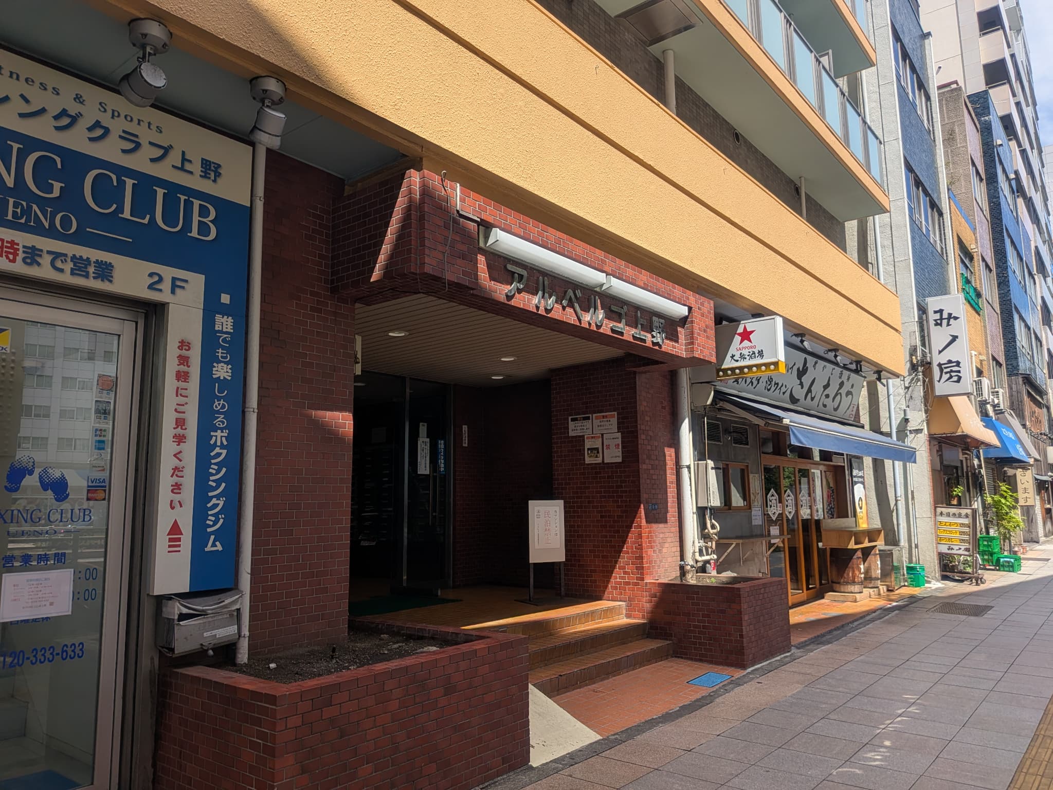 アルベルゴ上野の建物入口。赤茶色の外壁と建物名の表示が目印です